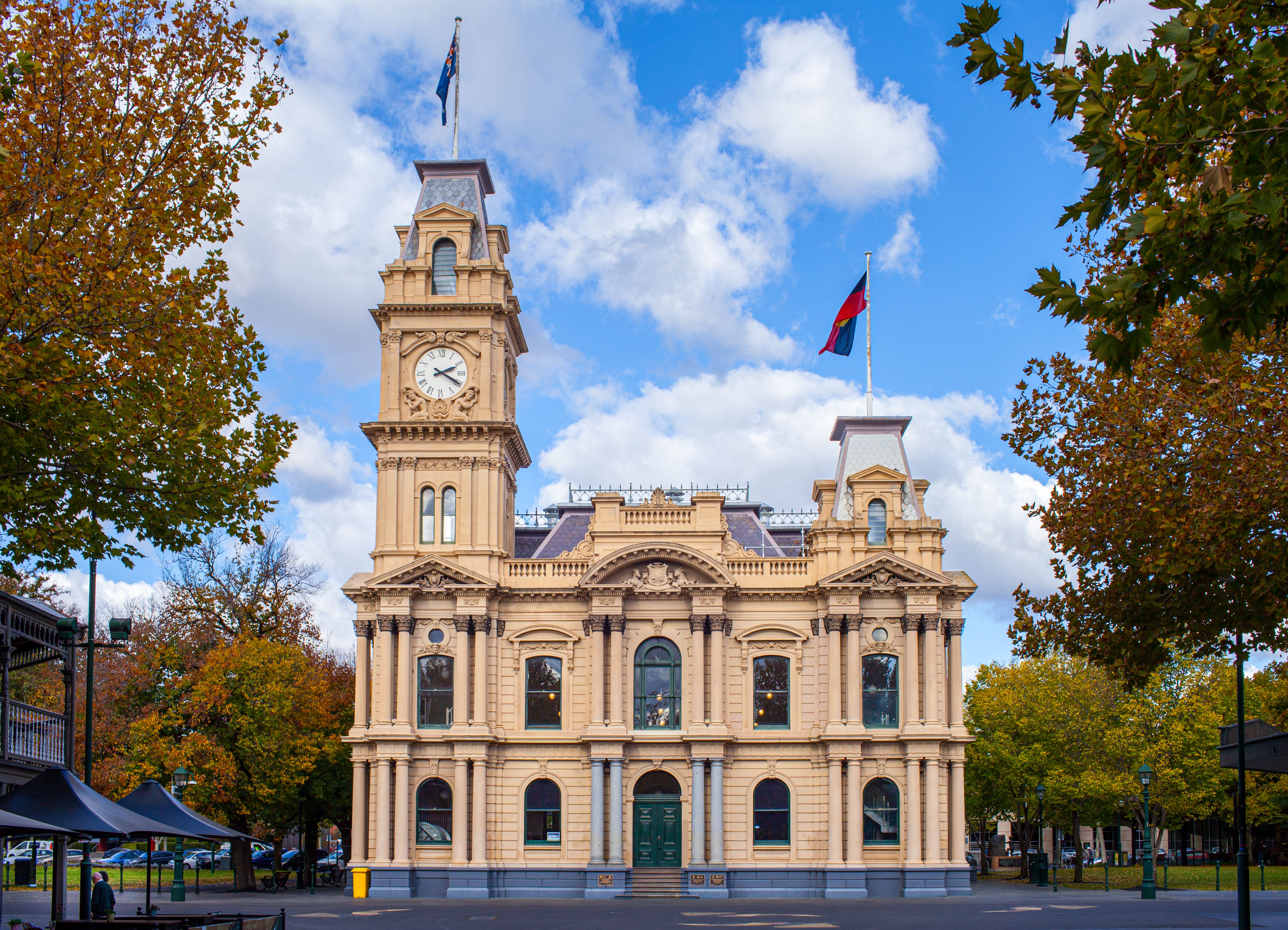 A government building with flags under an overcast sky