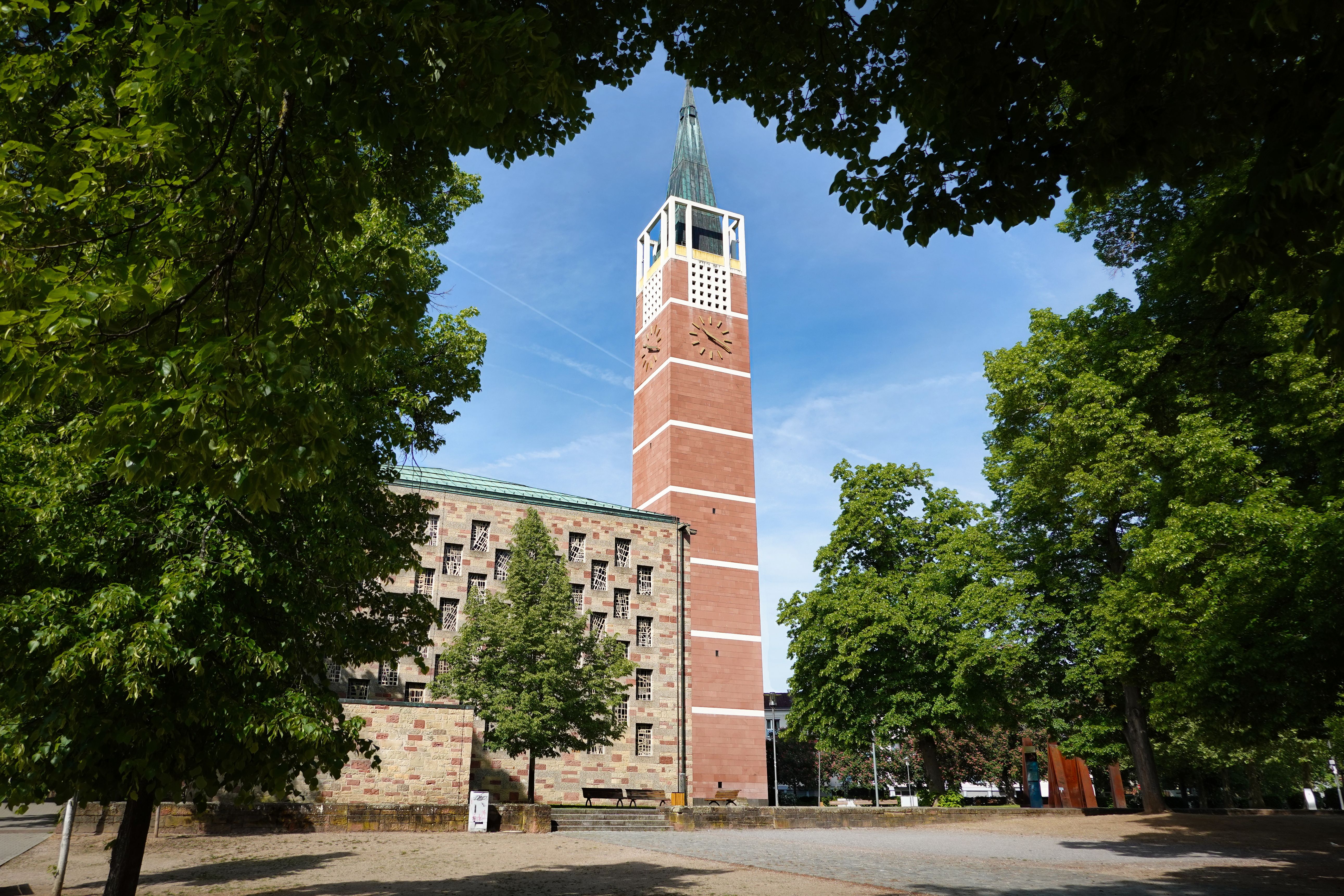 The Stadtkirche in Pforzheim showcasing its distinctive architecture amidst lush greenery on a sunny day.