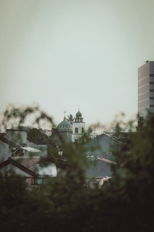 Free A serene view of Jakarta's skyline featuring a historic mosque dome amidst modern architecture. Stock Photo