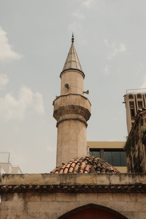 Free A towering minaret stands gracefully under a clear gray sky, showcasing Islamic architecture. Stock Photo