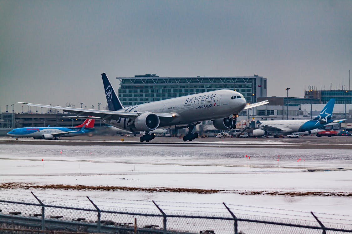 Free Aircraft flying over runway near airport building Stock Photo