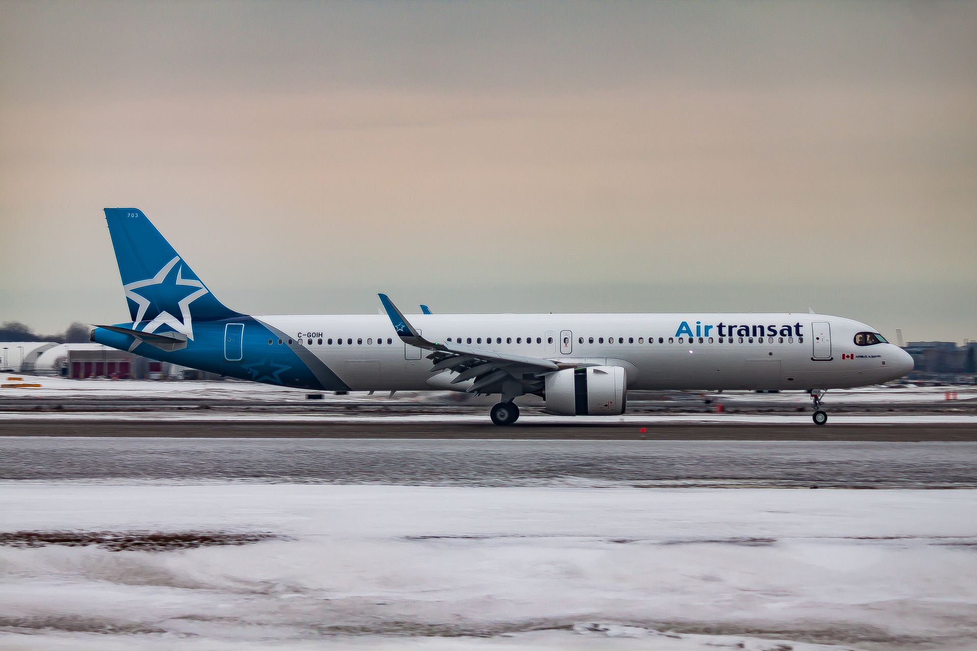 Passenger aircraft moving on airfield after landing in airport during sunset on winter day