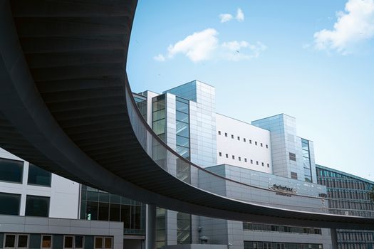 Contemporary building in Copenhagen, Denmark with a striking skywalk under a blue sky.