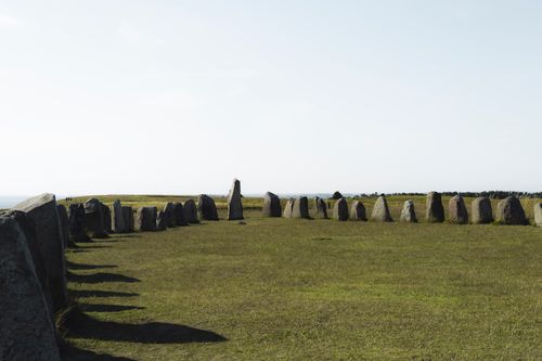 Free Explore the ancient Ales Stenar stone circle set against a clear blue sky in Sweden. Stock Photo