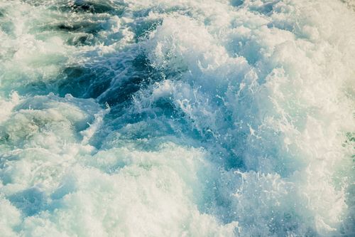 Free Captivating close-up of ocean waves crashing with powerful, foamy textures and vibrant blue hues. Stock Photo