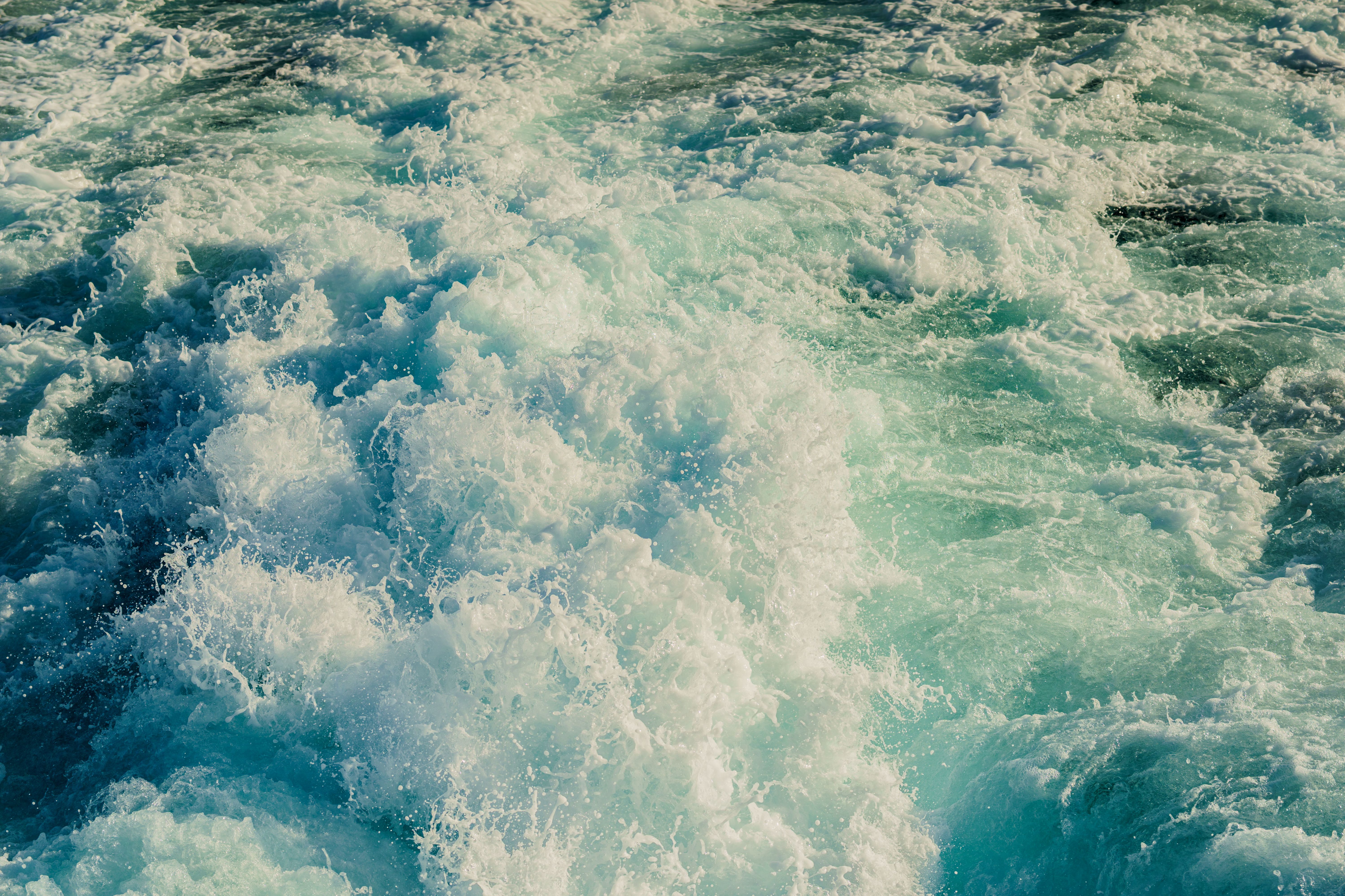 POV shot of a hand pointing towards endless ocean from a kayak, symbolizing adventure and exploration.