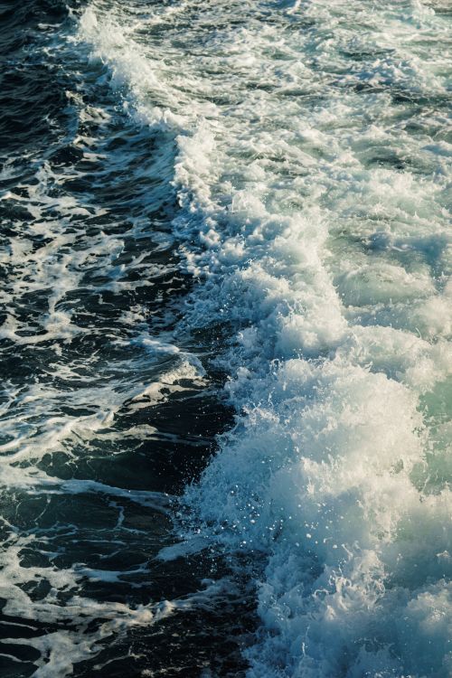 Free A captivating view of ocean waves crashing and creating foamy patterns on the water surface. Stock Photo