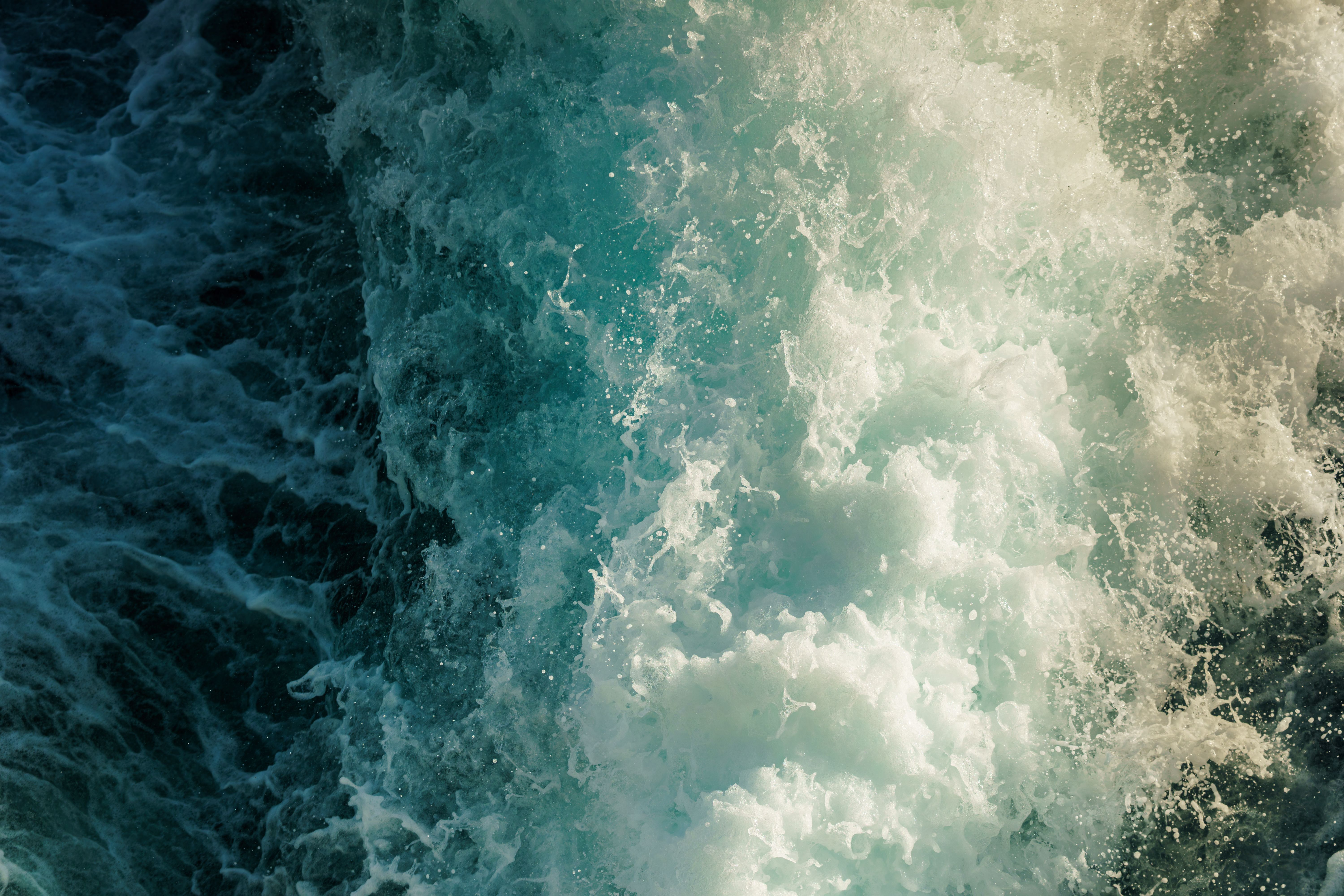 High-energy ocean wave crashing with splashes in vibrant blue tones. Perfect for nature and adventure themes.