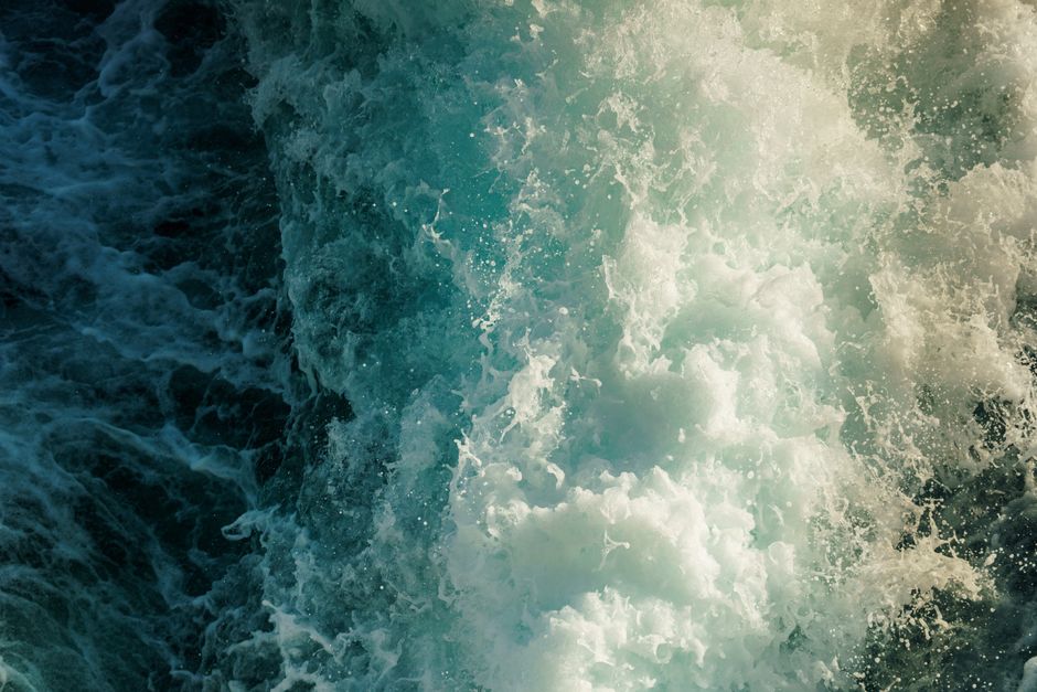 High-energy ocean wave crashing with splashes in vibrant blue tones. Perfect for nature and adventure themes.
