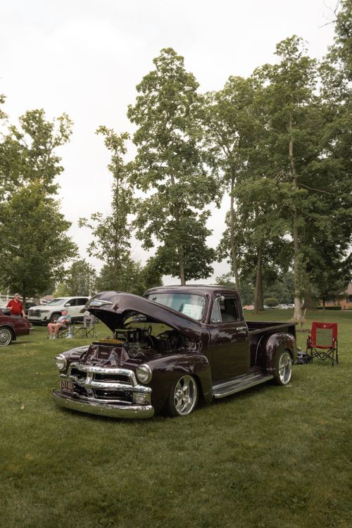 Free Vintage classic truck on display at an outdoor car show amidst lush greenery. Stock Photo