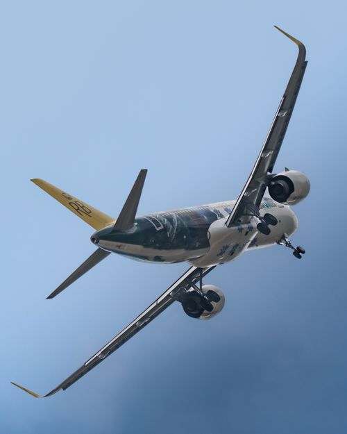 Free Airplane captured mid-flight against a clear blue sky in Sepang, Malaysia. Stock Photo