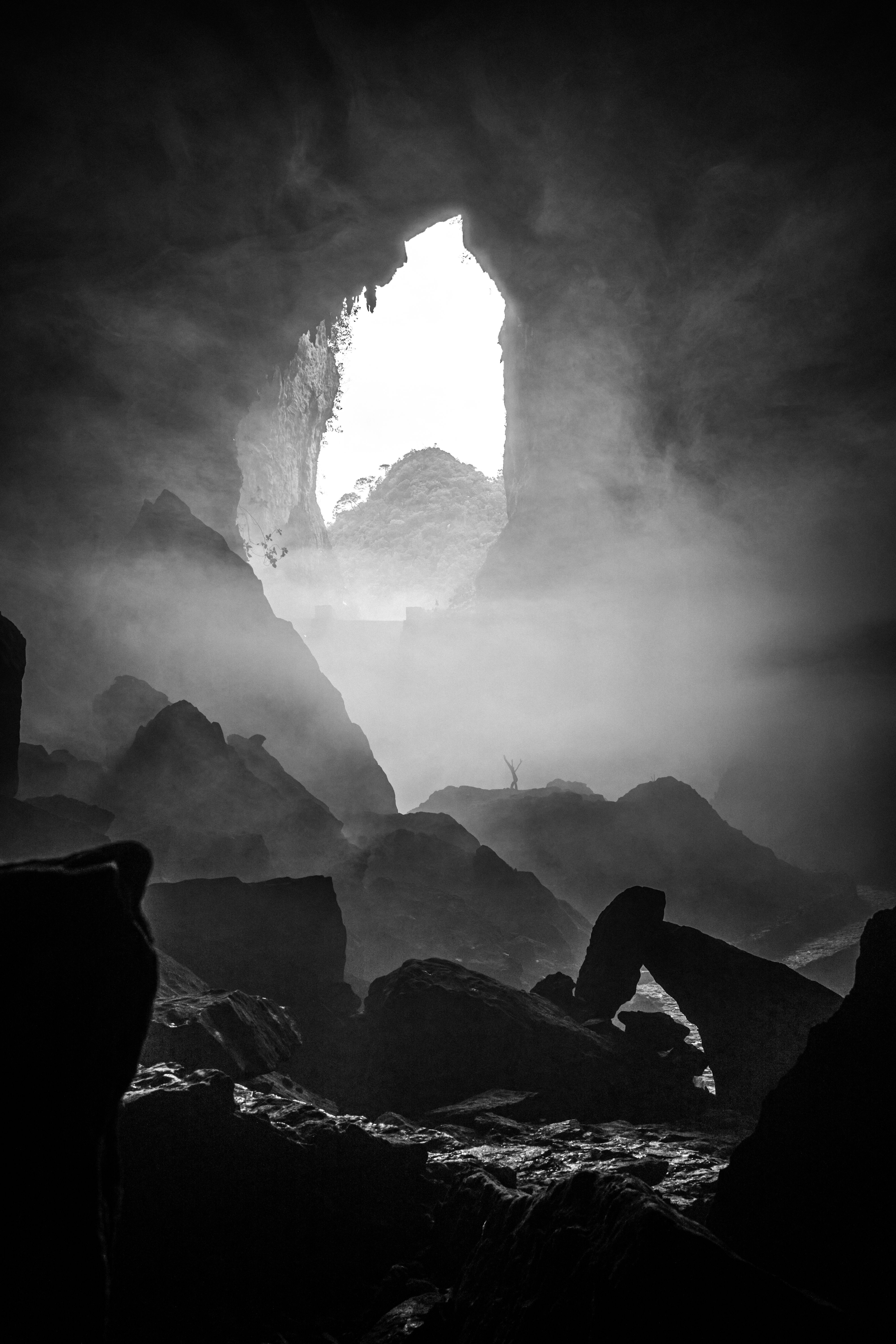 Black and white photo of a misty cave entrance in Dong Van, Hà Giang, Vietnam.