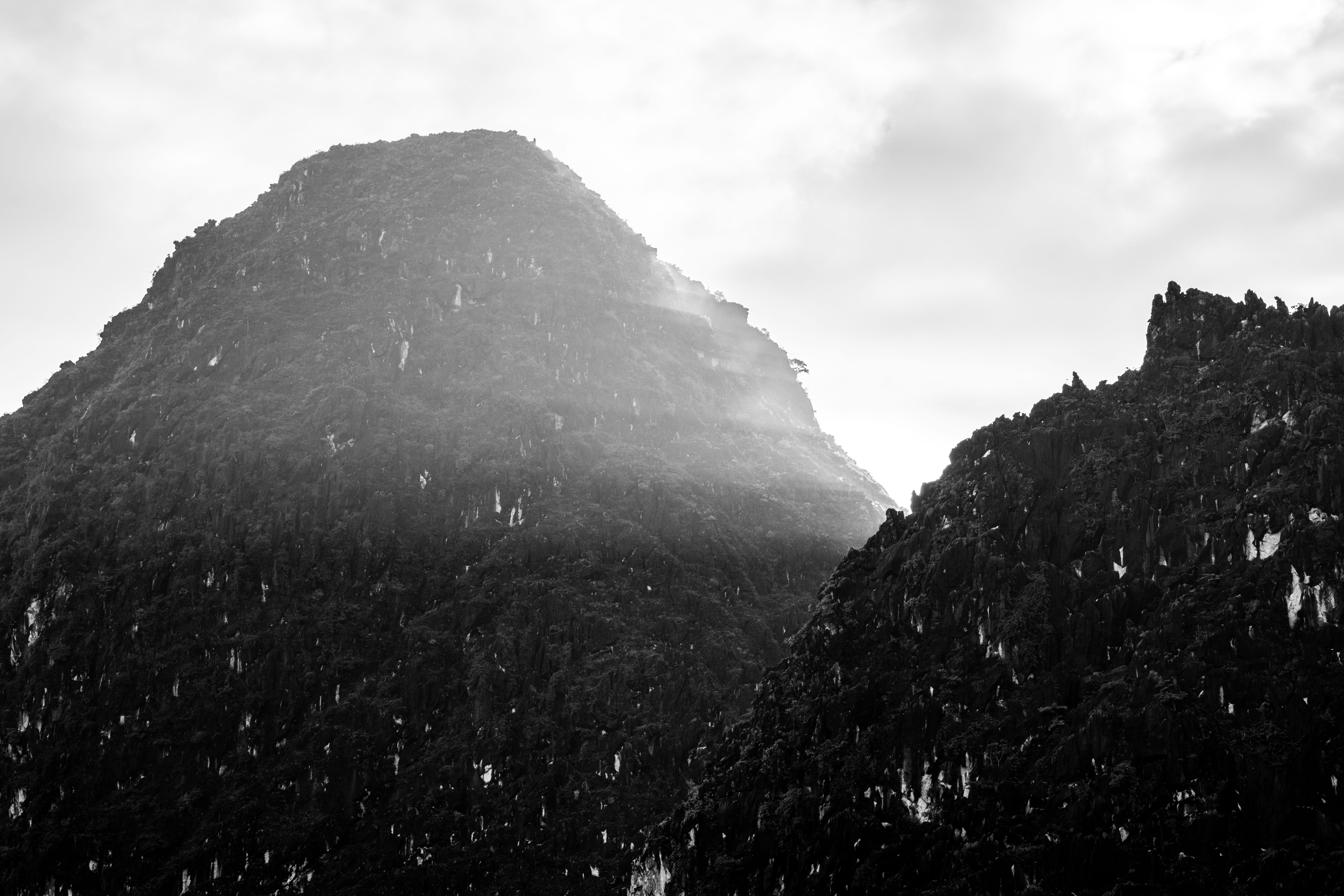 Black and white photo of mountain peaks shrouded in mist in Dong Van, Vietnam.