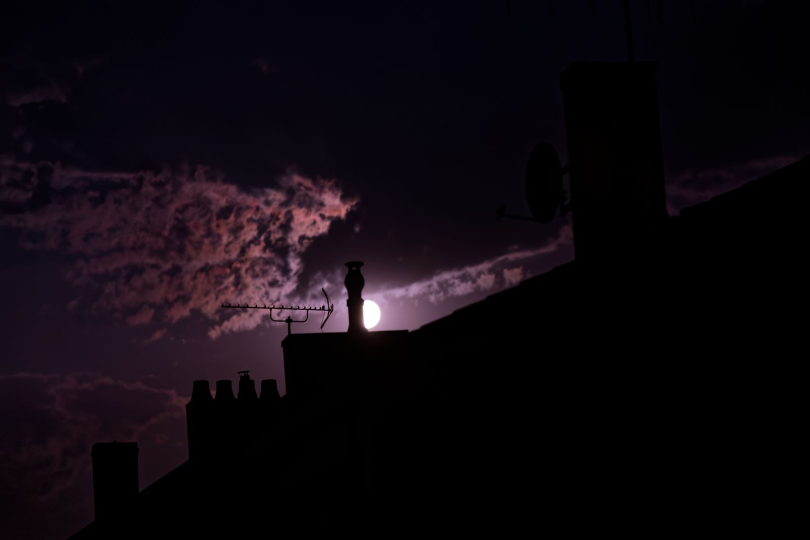 Pleine lune se levant derrière des cheminées, ciel nocturne violet