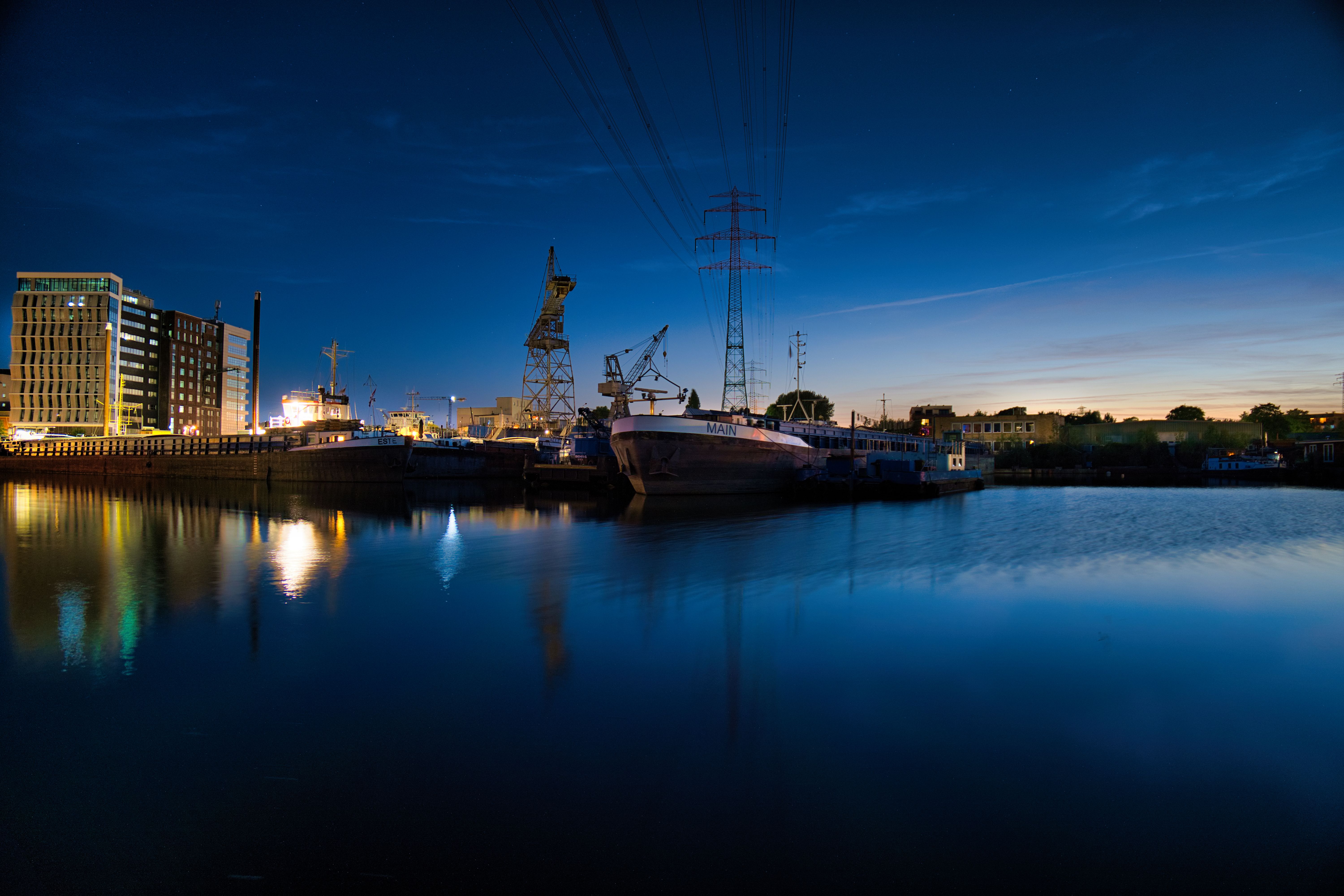 Harbor at dusk with lit buildings and docked ships