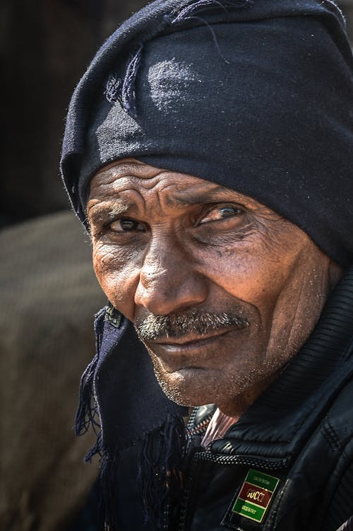 Man in Black Leather Jacket Wearing Black Cap in Close Up