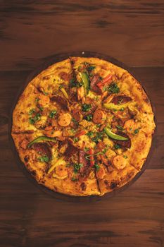 A vibrant homemade pizza topped with fresh vegetables and herbs, captured from above.