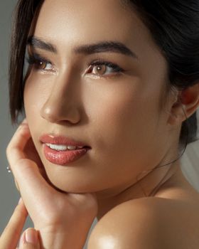 Close-up portrait of a woman with soft makeup and smooth skin, exuding elegance and grace.