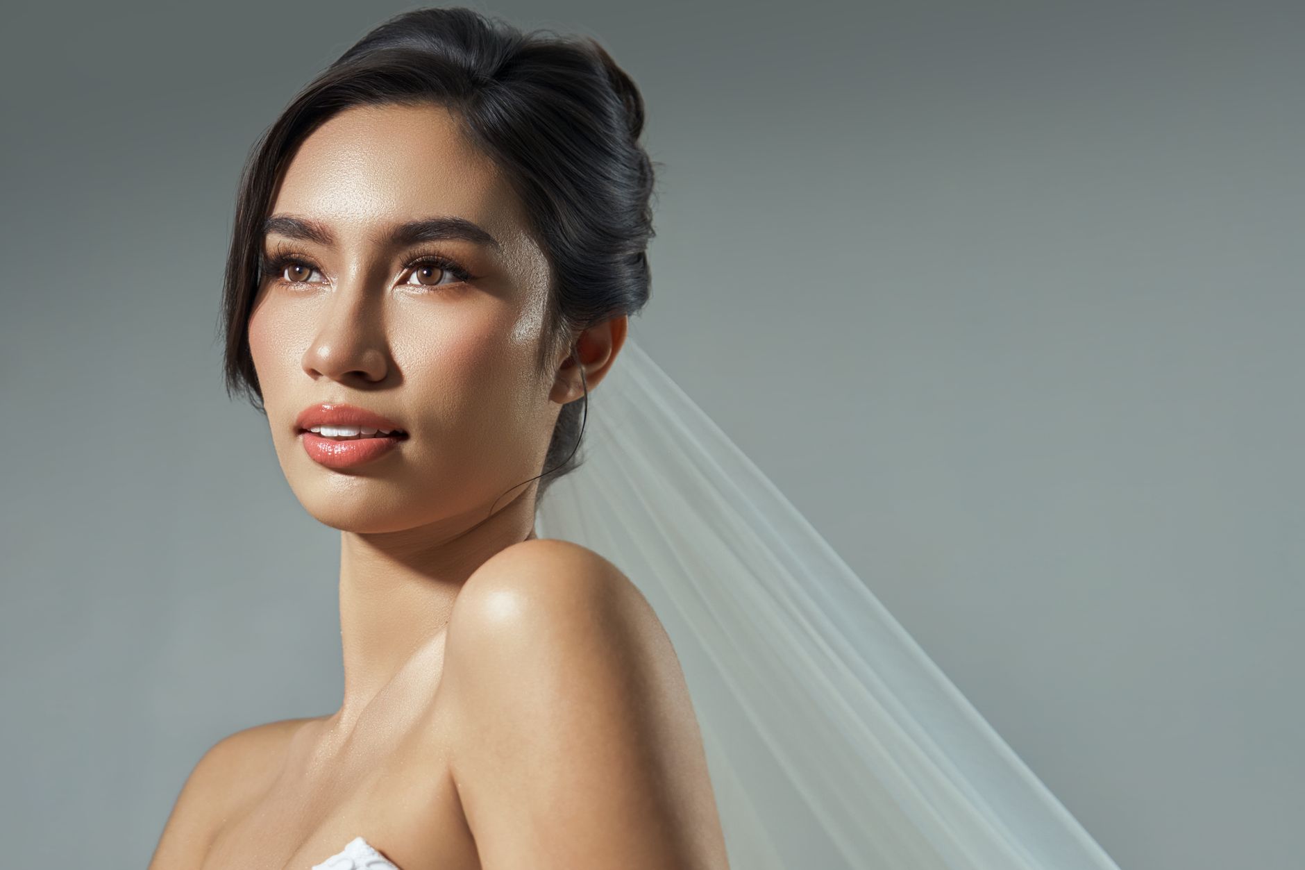 Portrait of a bride in soft lighting. Captures elegance and beauty with a focus on her serene expression.