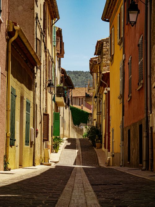 Free A picturesque narrow street with colorful facades in Cassis, showcasing classic Provence architecture on a sunny day. Stock Photo
