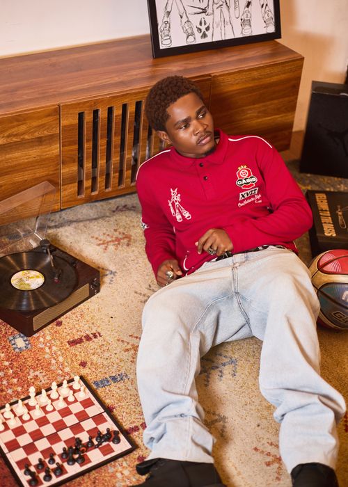 Free Young man enjoying leisure time with vinyl record, chess set, and basketball indoors. Stock Photo