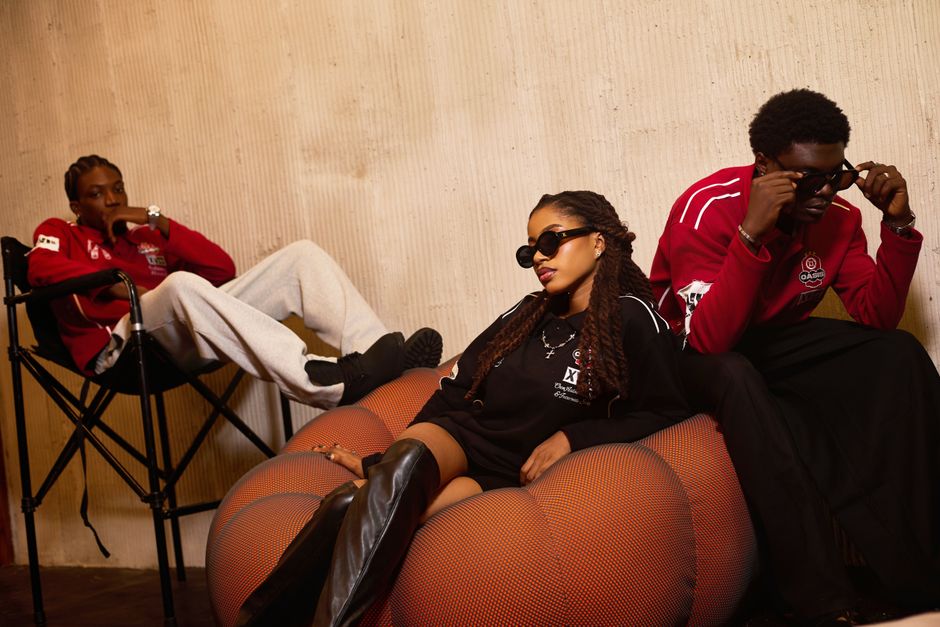Stylish group of young adults wearing sunglasses indoors showcasing casual fashion.