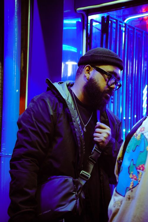 Free Stylistic portrait of a bearded man in an urban setting with vivid neon lighting. Stock Photo