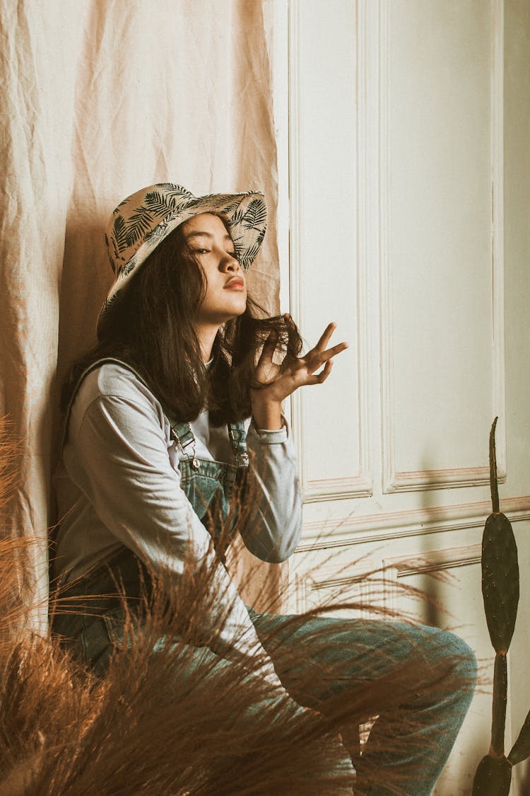 Confident Asian Teen Girl Sitting In Elegant Room During Photo Shoot