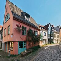 Cobbled lane lined with pastel gabled houses. Photo by E. Space on Pexels
