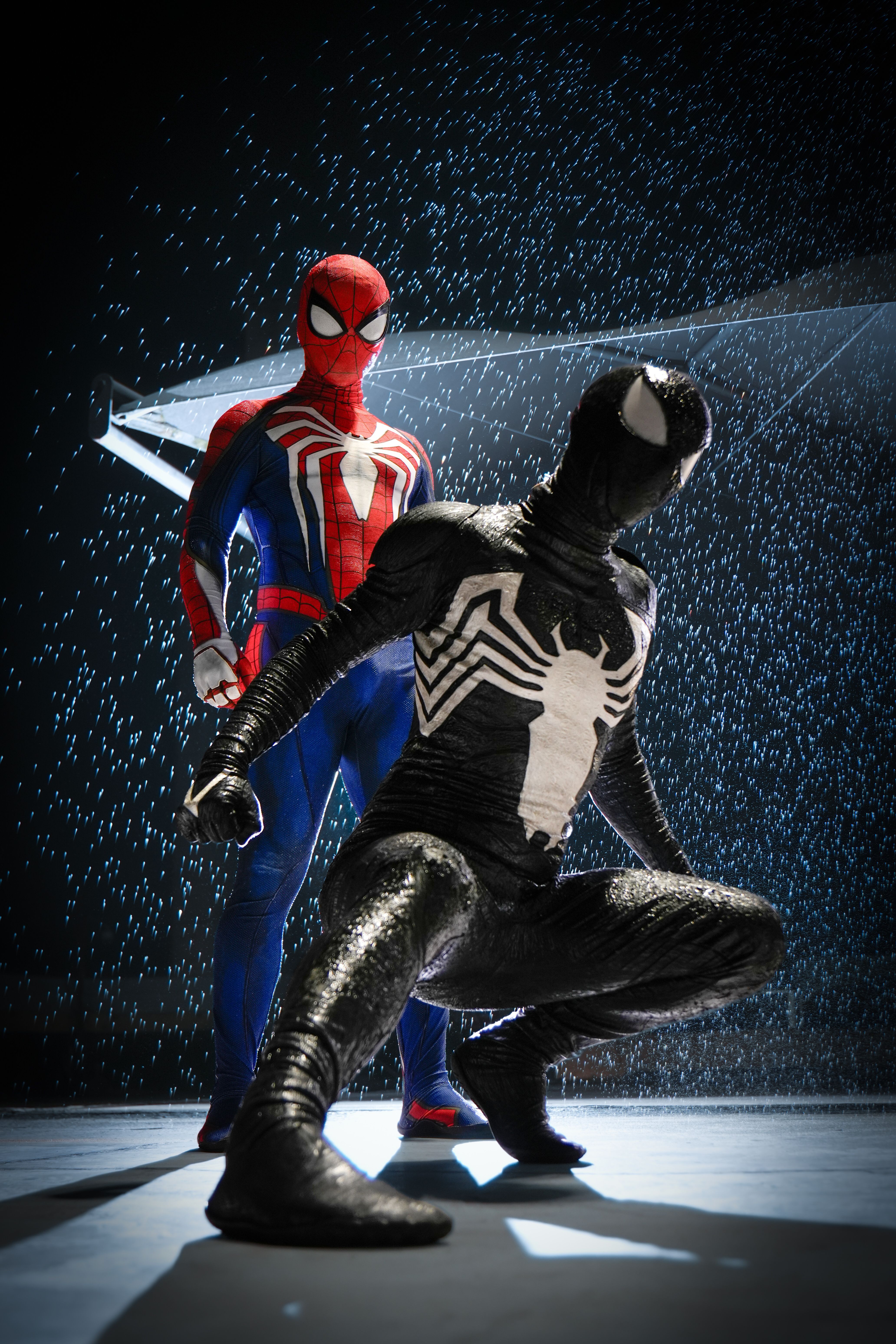 Two superheroes in dramatic poses in the rain, showcasing a dynamic cosplay scene.