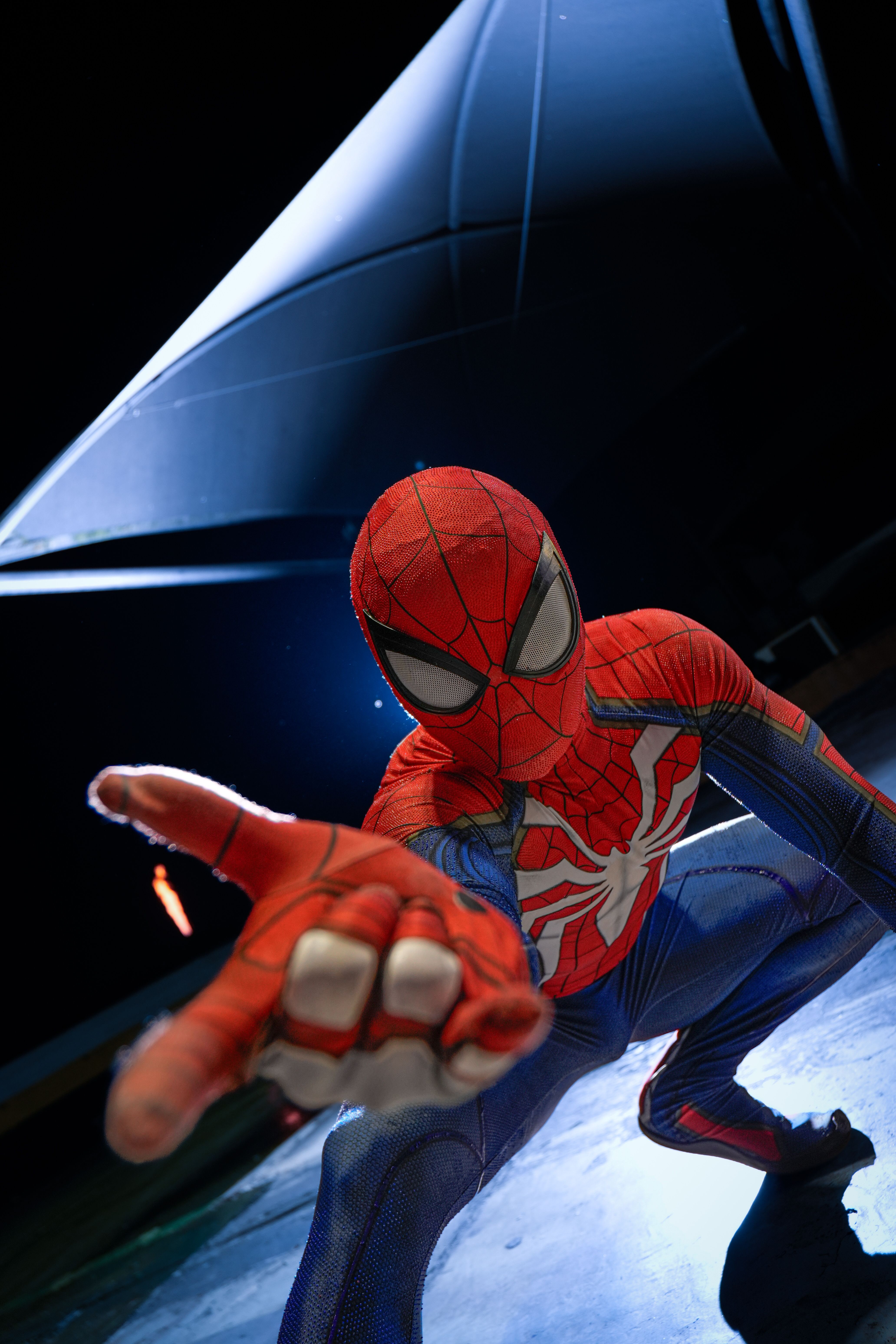 Spider-Man crouches indoors in a dynamic pose, showcasing heroic action.