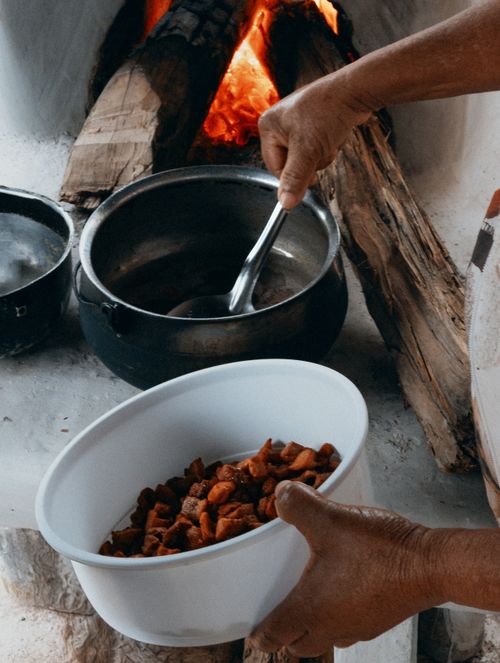 Free A person prepares food over a rustic wood fire in Brazil, showcasing traditional cooking methods. Stock Photo