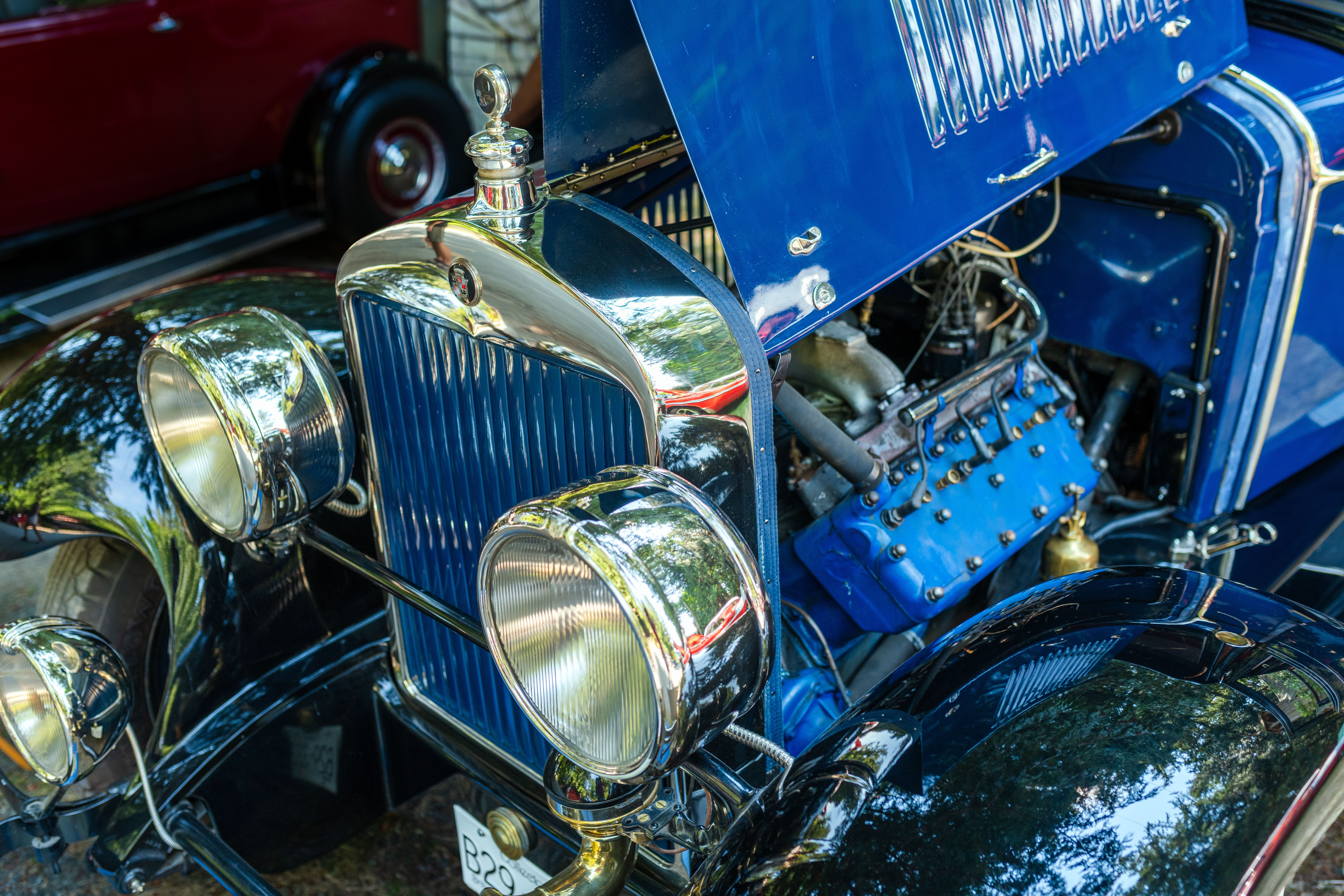 Close-up of a restored blue vintage Ford Model A with open hood at a classic car show in Victoria, BC.