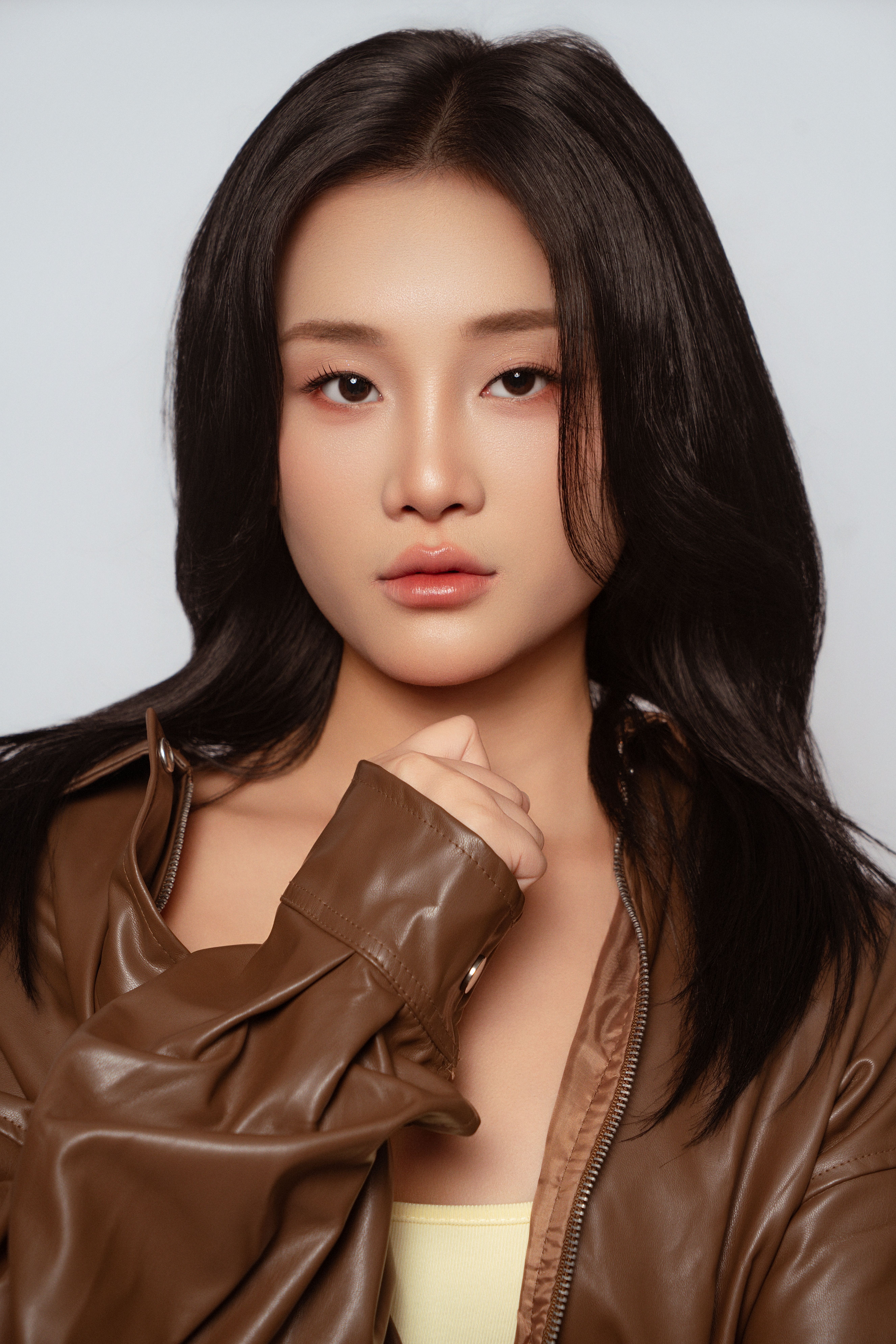 Stunning close-up of an Asian woman in a leather jacket with natural makeup.