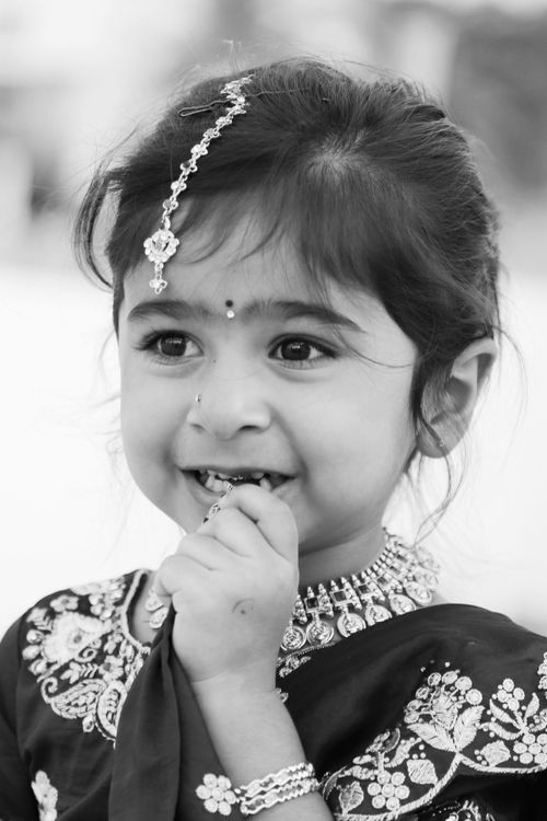 Free Black and white portrait of a smiling child in traditional attire. Stock Photo