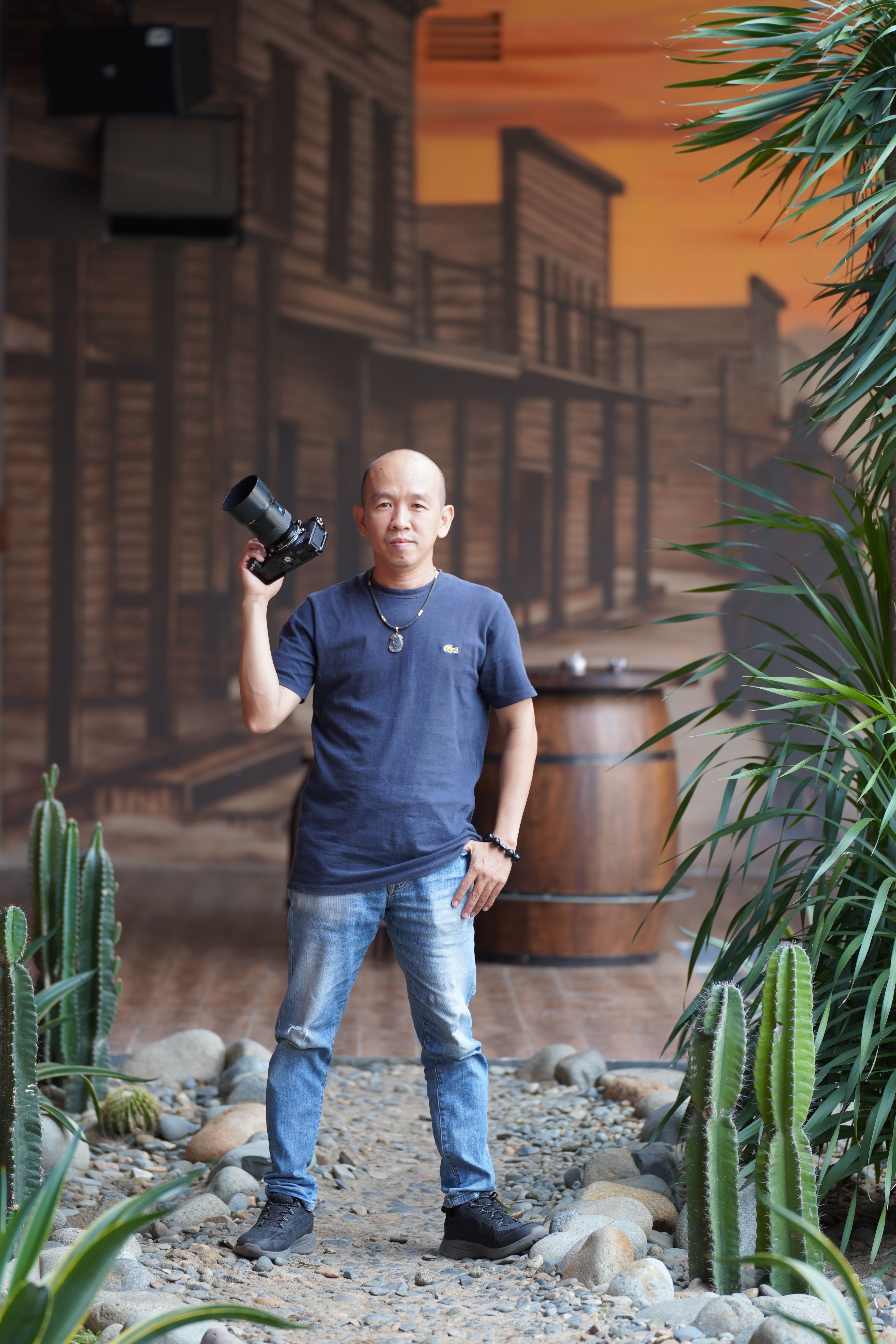 Portrait of a photographer in a Western-themed setting with cactus plants.
