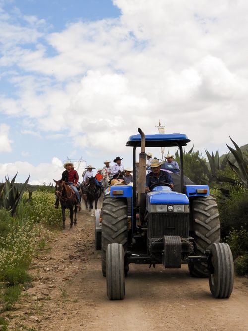 Free A rural scene in Mexico showing a tractor and people on horseback under a cloudy sky. Stock Photo