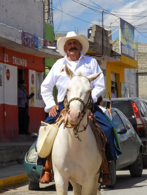 Free A Mexican man in traditional charro attire rides a horse down a city street. Stock Photo