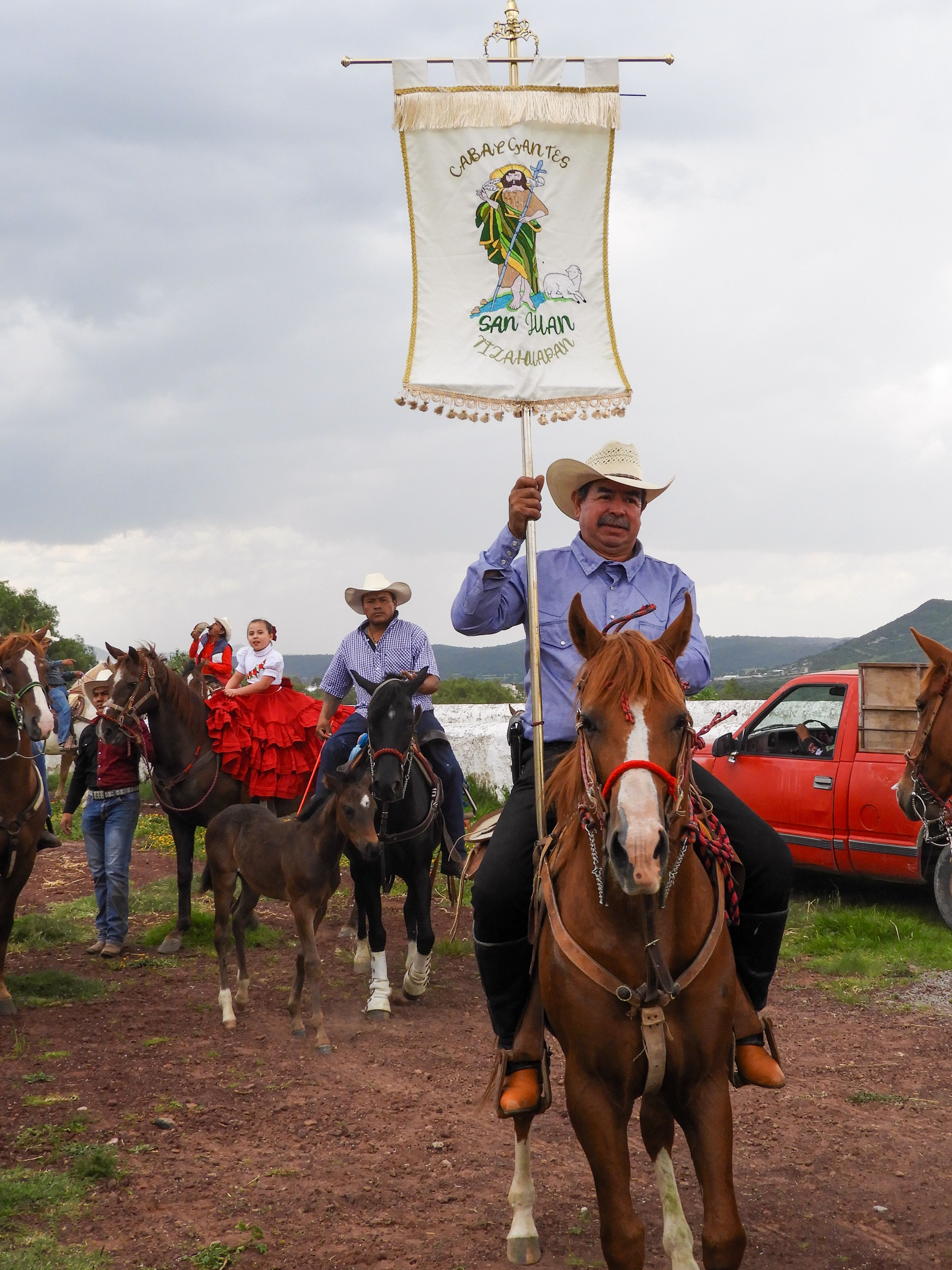 A vibrant horseback procession in México showcasing cultural traditions and attire.