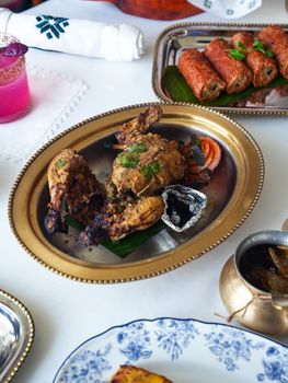 A delicious Indian platter featuring grilled chicken, kebabs, and a refreshing drink, ideal for festive occasions.