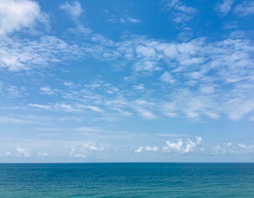 Free A serene ocean view with a vibrant, cloudy sky, capturing the beauty of nature and a peaceful summer day. Stock Photo