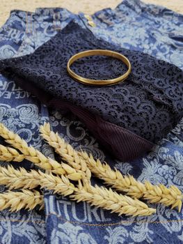 Elegant lace with a bangle on denim featuring wheat, embodying rustic fashion.