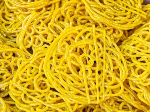 Free Vibrant and detailed image showing a close-up view of raw, coiled yellow egg noodles. Stock Photo