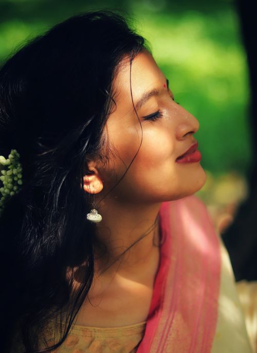 Free A peaceful portrait of a woman basking in sunlight, highlighting elegance and serenity. Stock Photo