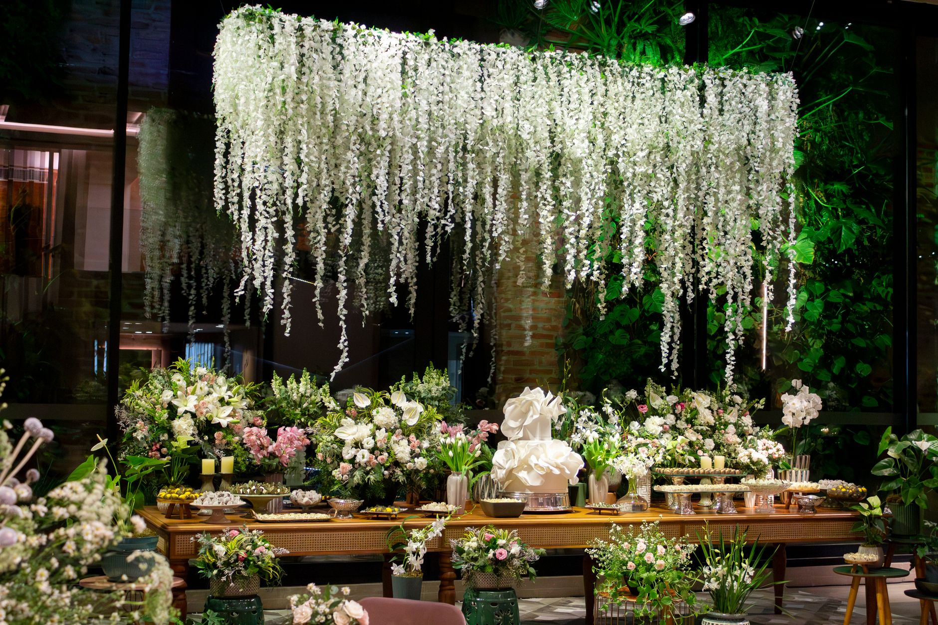 Luxurious wedding setup featuring cascading white flowers and elegant floral arrangements in São Paulo.