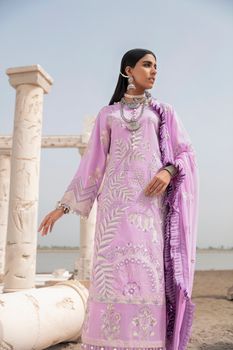 Stylish woman poses in lavender dress at historic site with columns.