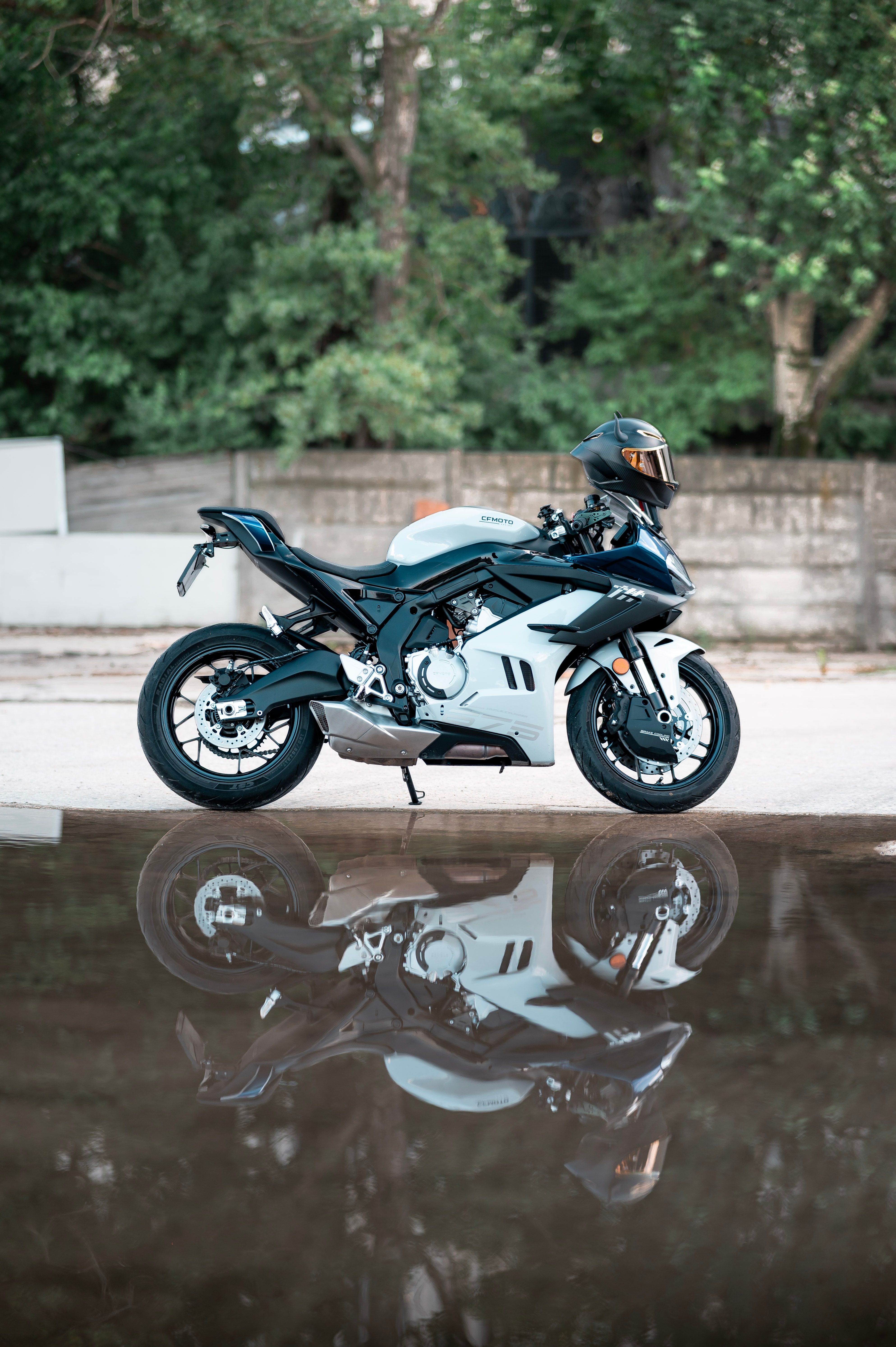 A sleek motorcycle reflecting in a puddle, showcasing modern design and style.