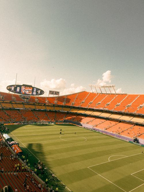 Free Panoramic view of a vibrant football stadium packed with fans, under a clear blue sky. Stock Photo