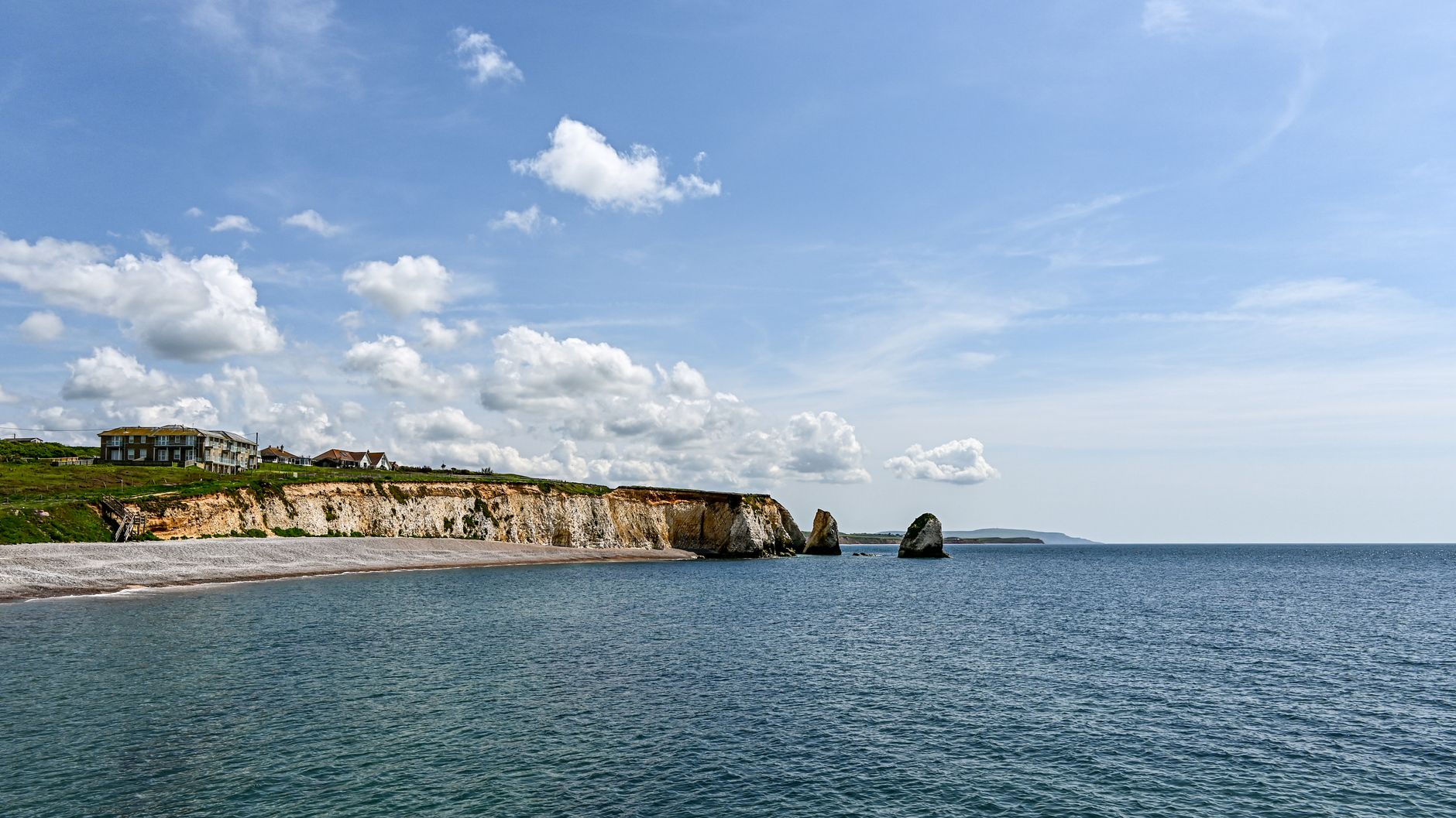 Beautiful coastal landscape of Freshwater Bay with cliffs and blue sky on a sunny day.