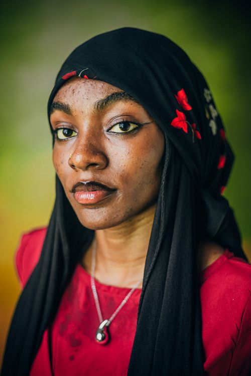 Free Captivating portrait of a woman wearing a decorated headscarf, expressing confidence and grace. Stock Photo